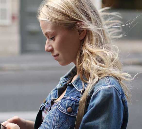 woman looking down at phone