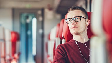 Man sitting on train wearing headphones