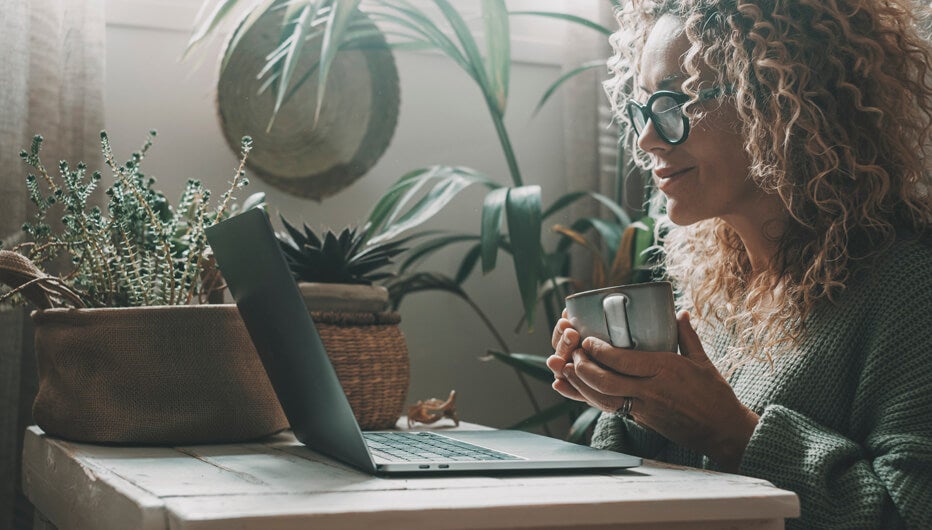 woman looking at screen with coffee