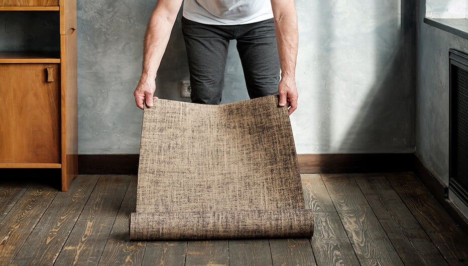 man unrolling mat