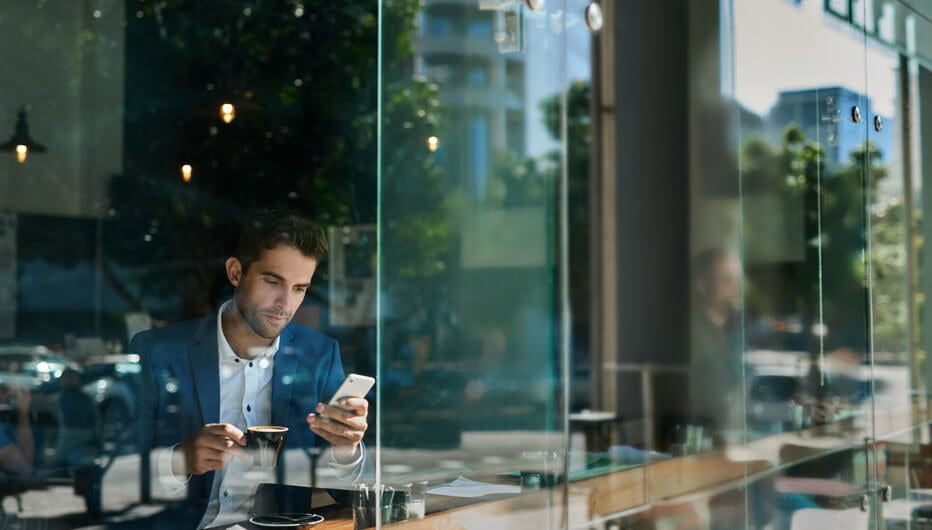 Man on phone in cafe outside reflection