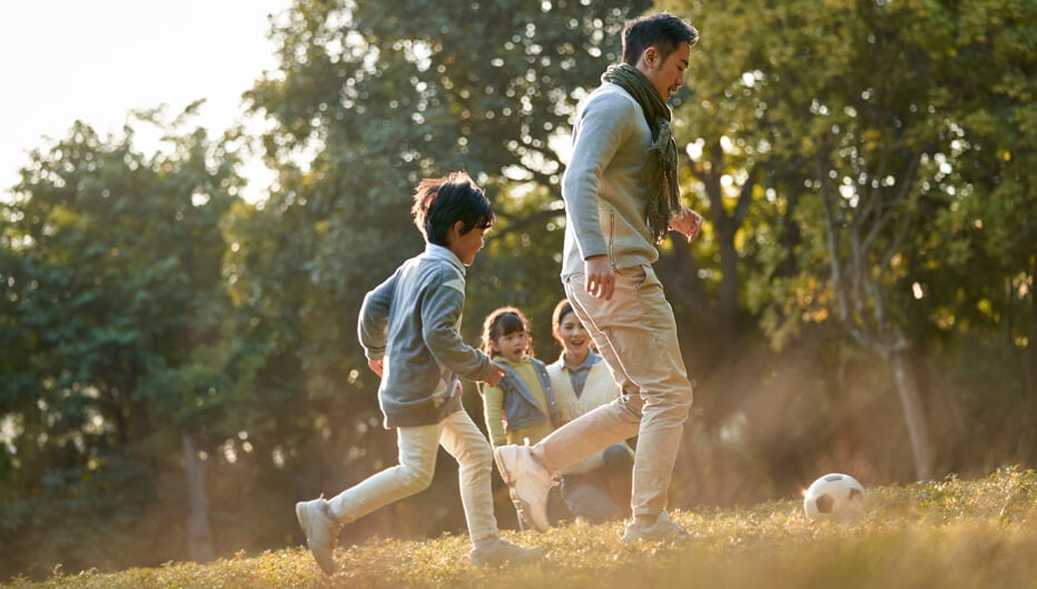 young family playing football