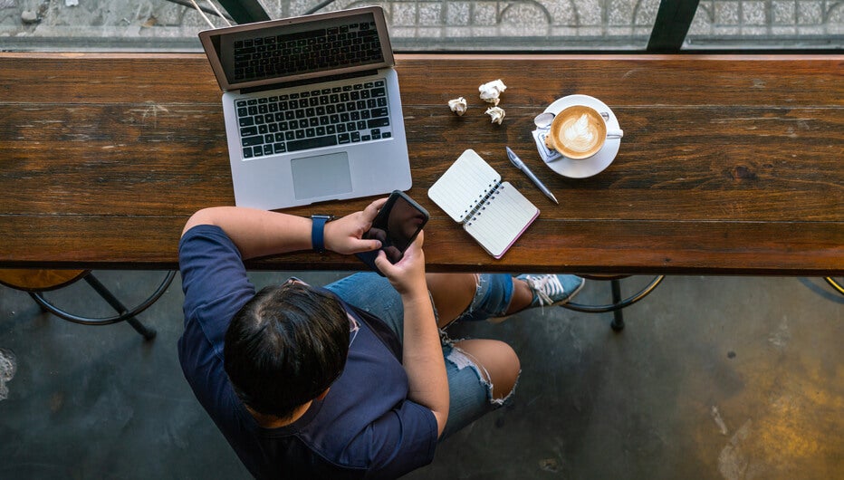 ariel view of man with laptop and coffee at table