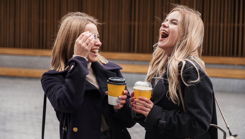 two women laughing having coffee, happy with their workplaces positive employee value proposition (EVP)