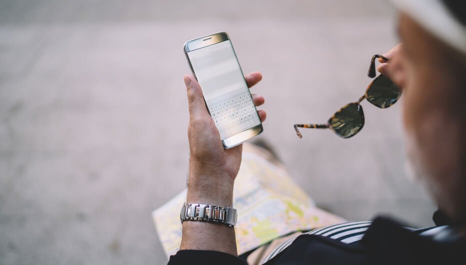 man with sunglasses checking phone 