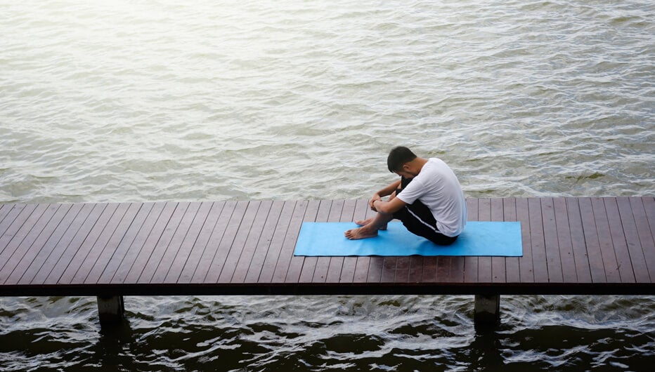 man with mat on jetty