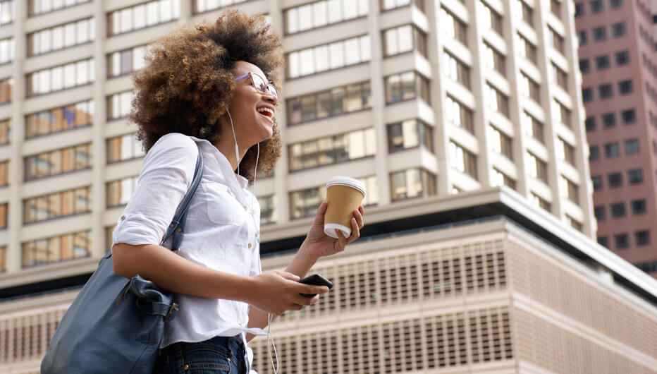 women walking and smiling in city with coffee
