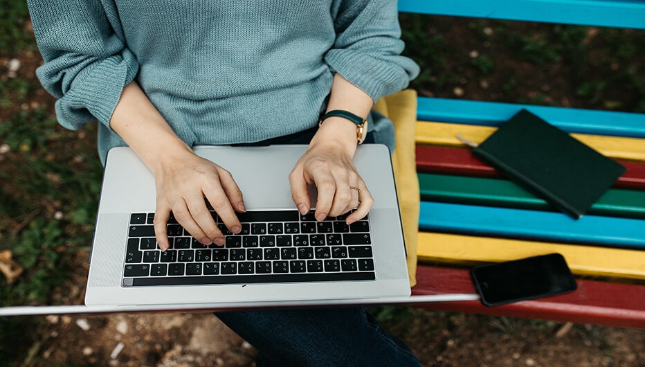 working on laptop on multi coloured bench