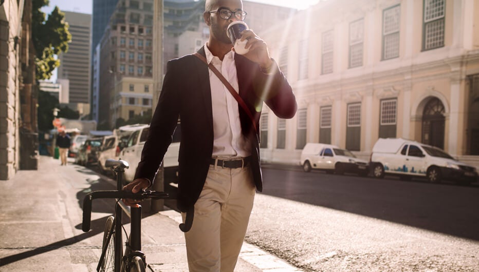 man walking with bicycle and coffee