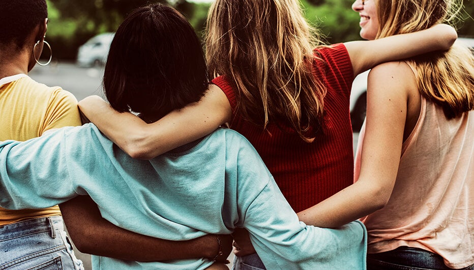 four friends with arms around each other