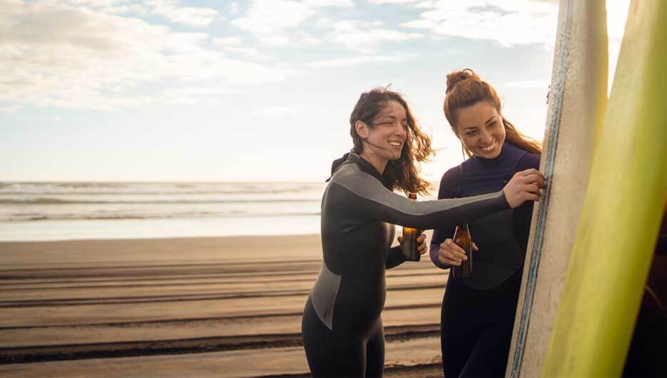 women examining surfing board
